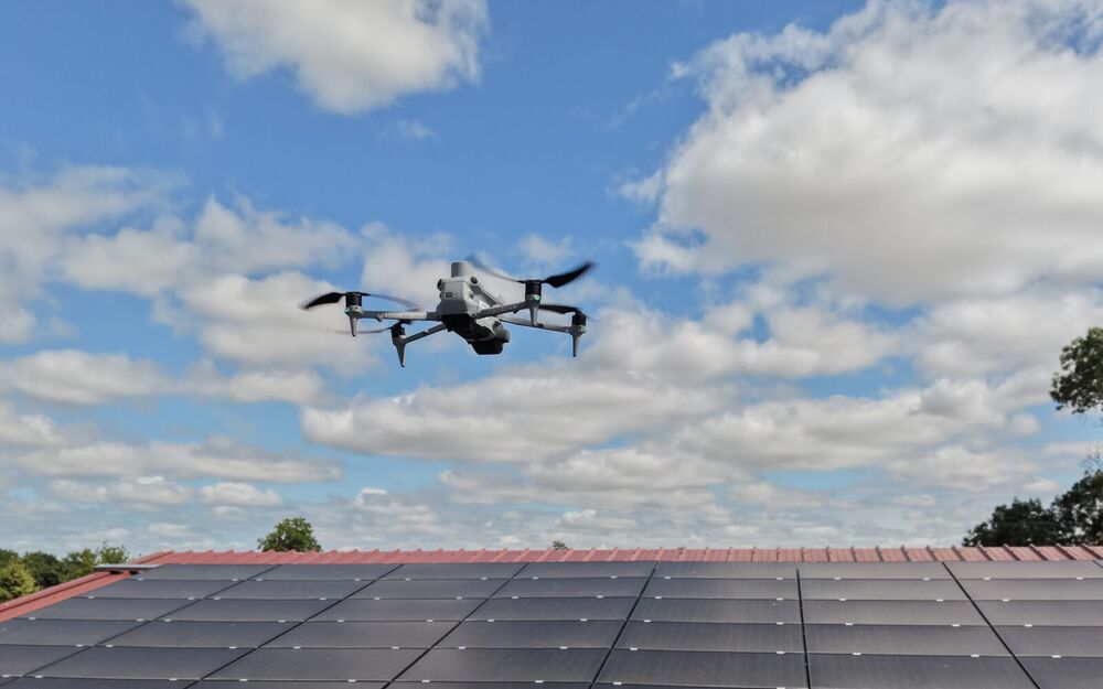 Drone d'inspection en vol au-dessus d'une toiture photovoltaïque
